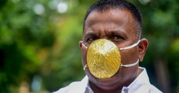Koronavirüsten korunmak için altın maske takıyor